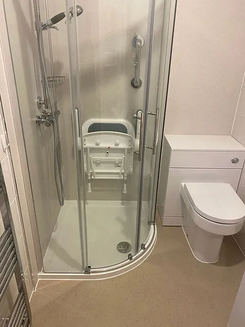 a white toilet sitting next to a walk in shower
