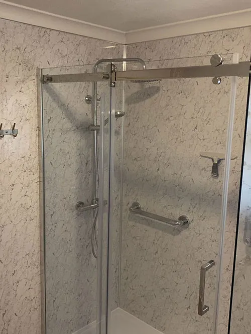 a bathroom with a walk in shower next to a toilet