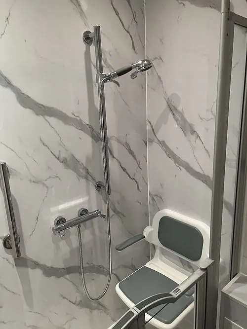 a bathroom with a shower and a chair